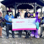 A photo of the VancouFur charity team presenting a giant cheque to Qmunity